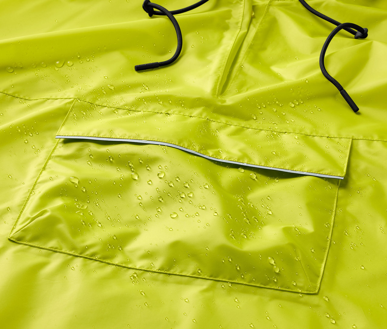Gros plan sur un poncho de pluie jaune avec des gouttes d'eau et un cordon de serrage noir.