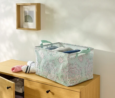 Une boîte de rangement pliable est posée sur une commode.