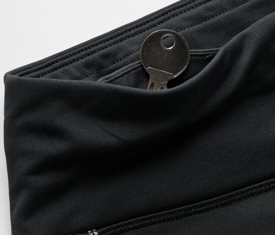 Gros plan sur un legging noir avec une clé dans la poche.