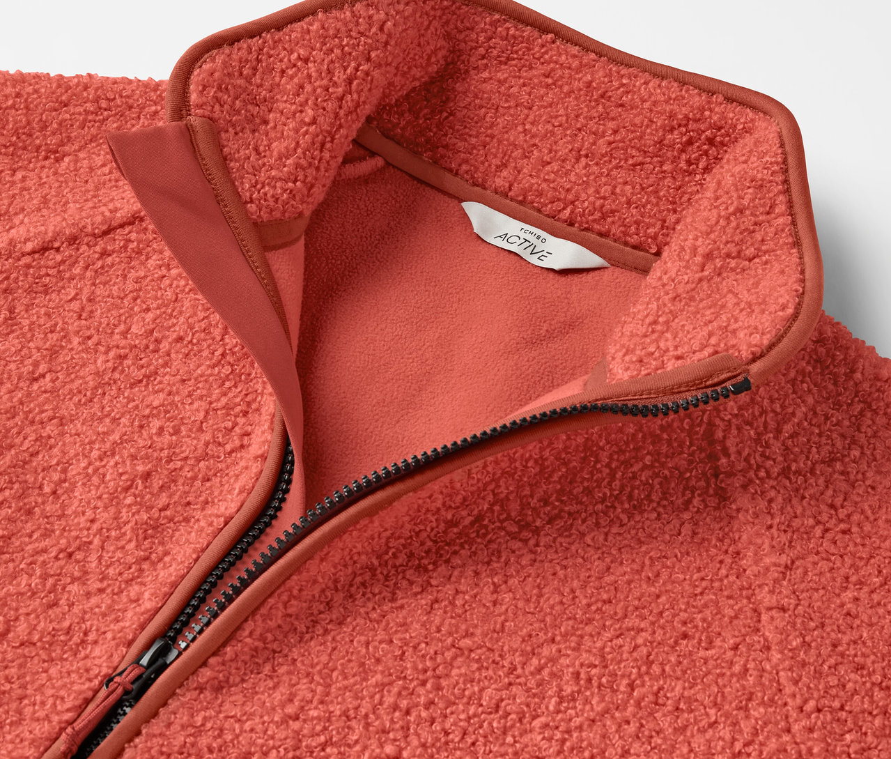 Vue détaillée d'une veste en polaire corail avec fermeture éclair.