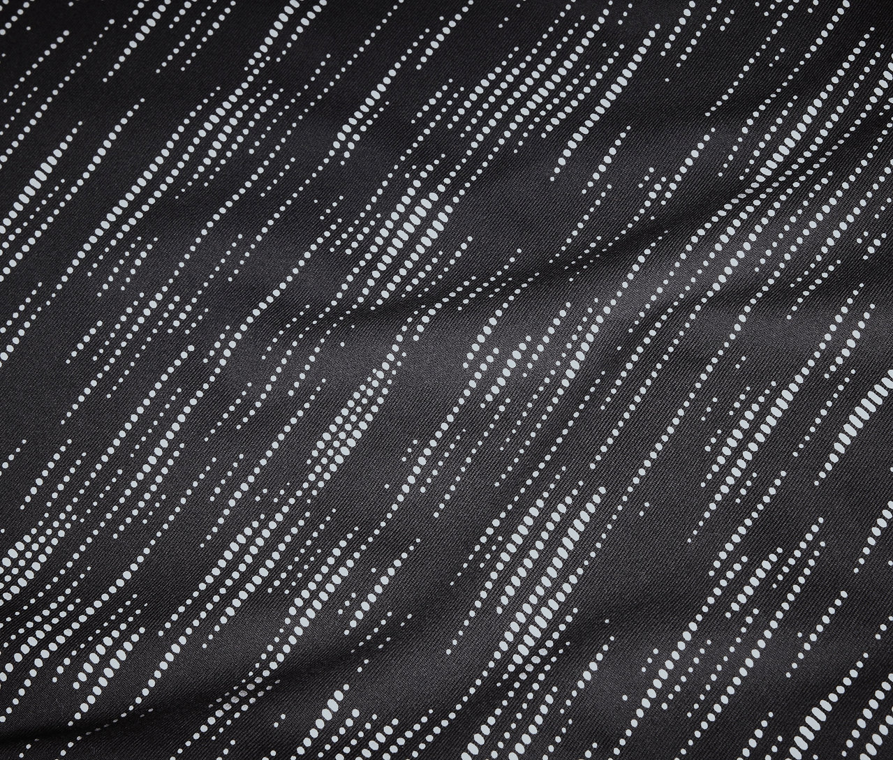 Gros plan d'un tissu noir avec des lignes diagonales pointillées blanches.