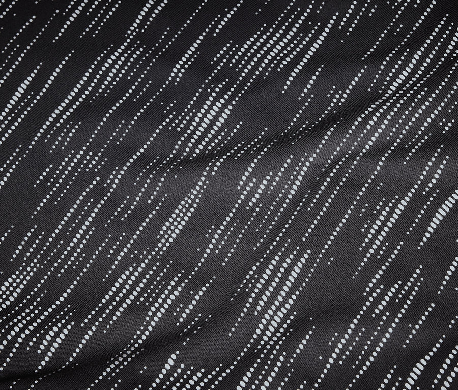 Gros plan d'un tissu noir avec des lignes diagonales pointillées blanches.