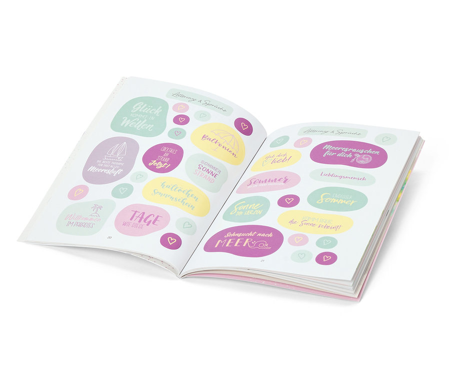 Livre ouvert avec autocollants d'été, dont « Glück Wellen », « Sonne Strand » et « Sehnsucht nach Meer ».