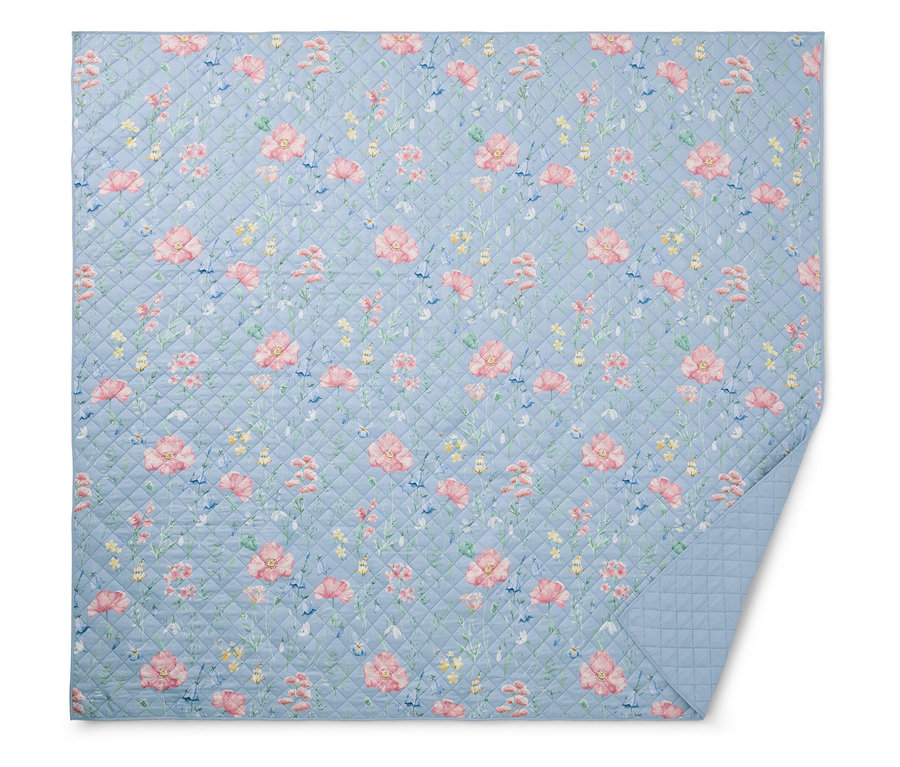 Couverture matelassée bleu clair à motifs floraux.