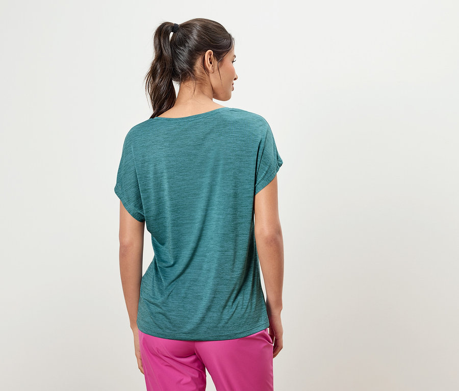 Vue arrière d'une femme avec une queue de cheval portant un t-shirt bleu-vert et un pantalon rose.