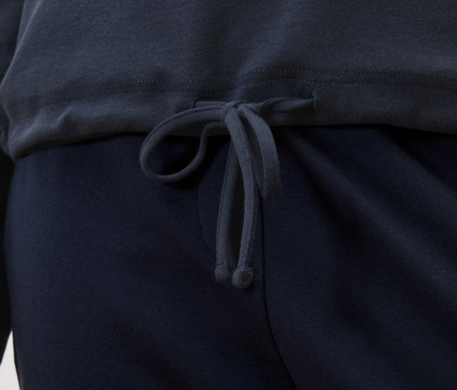 Gros plan d'un haut bleu marine avec cordon de serrage sur un pantalon bleu marine.