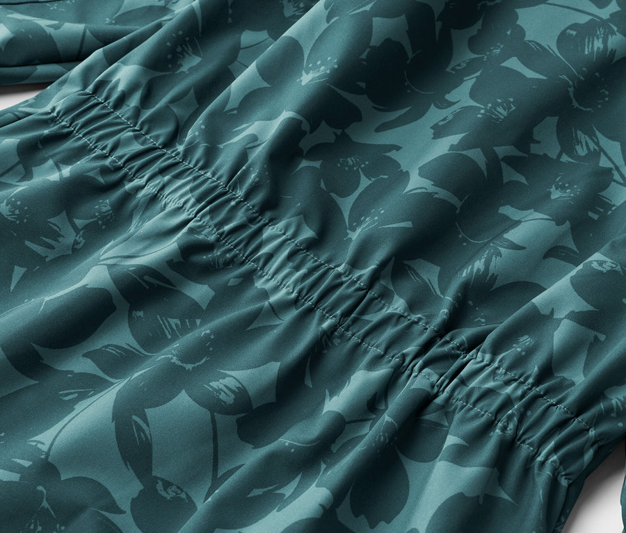 Gros plan d'un tissu turquoise avec un motif floral plus foncé et un cordon de serrage.