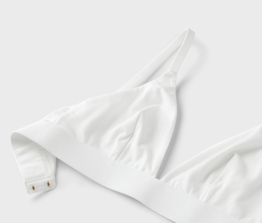 Gros plan d'un soutien-gorge blanc à bretelles fines sur fond blanc.