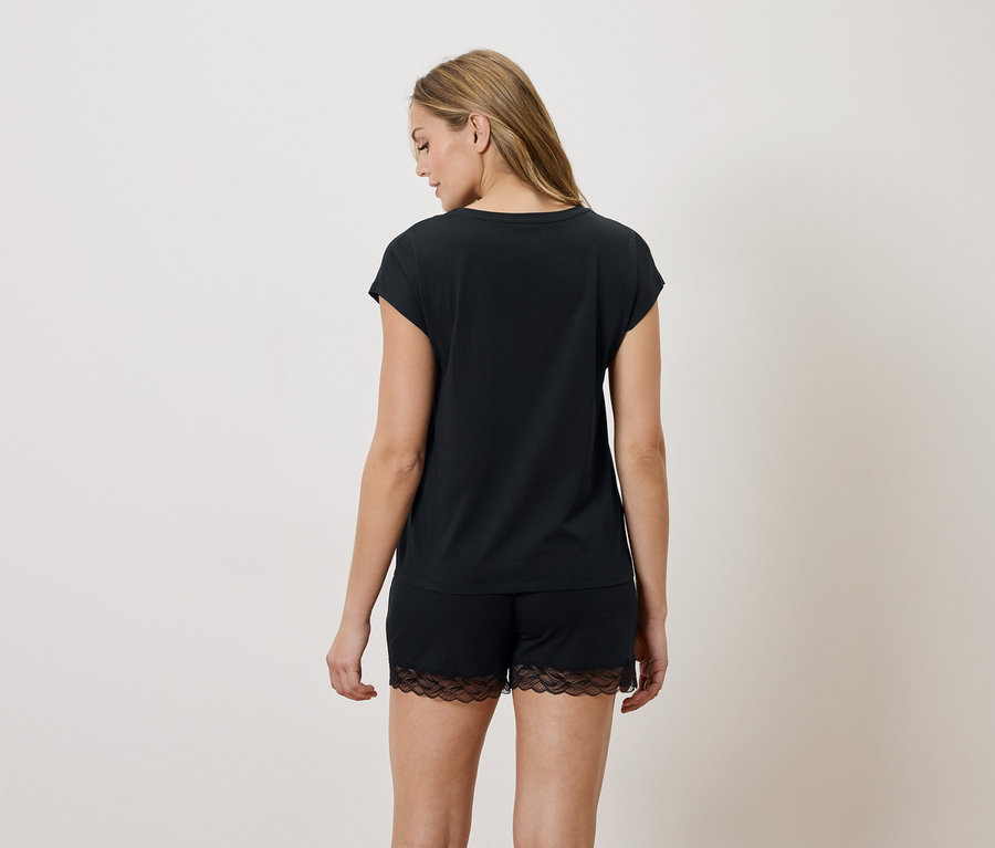 Femme vue de dos portant un t-shirt noir et un short avec des détails en dentelle.