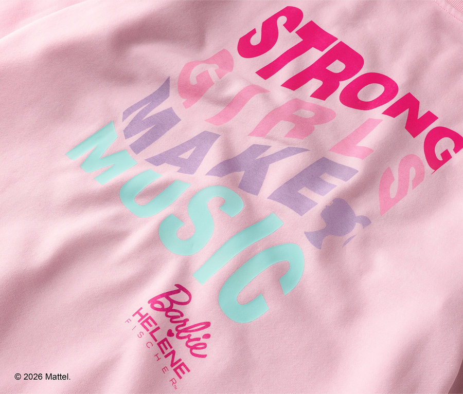 Gros plan sur un sweat-shirt rose avec l'inscription "STRONG GIRLS MAKE MUSIC" en différentes couleurs.