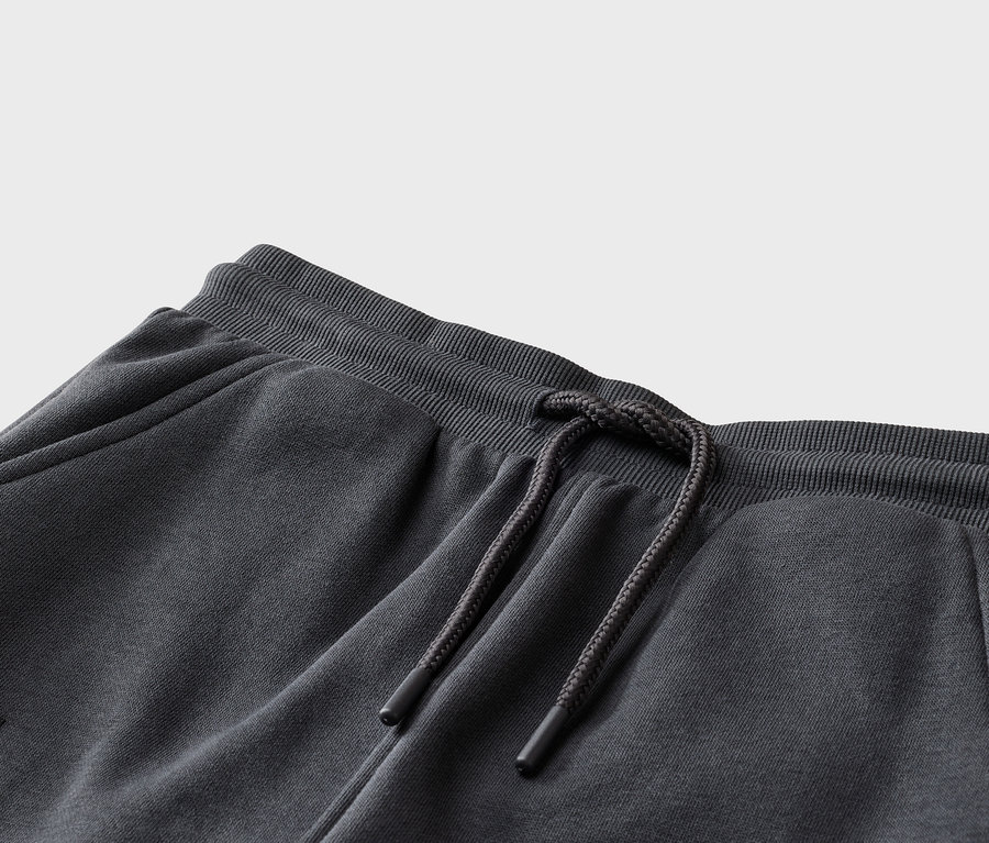 Gros plan d'un pantalon de jogging gris avec cordon de serrage à la taille et poche latérale.