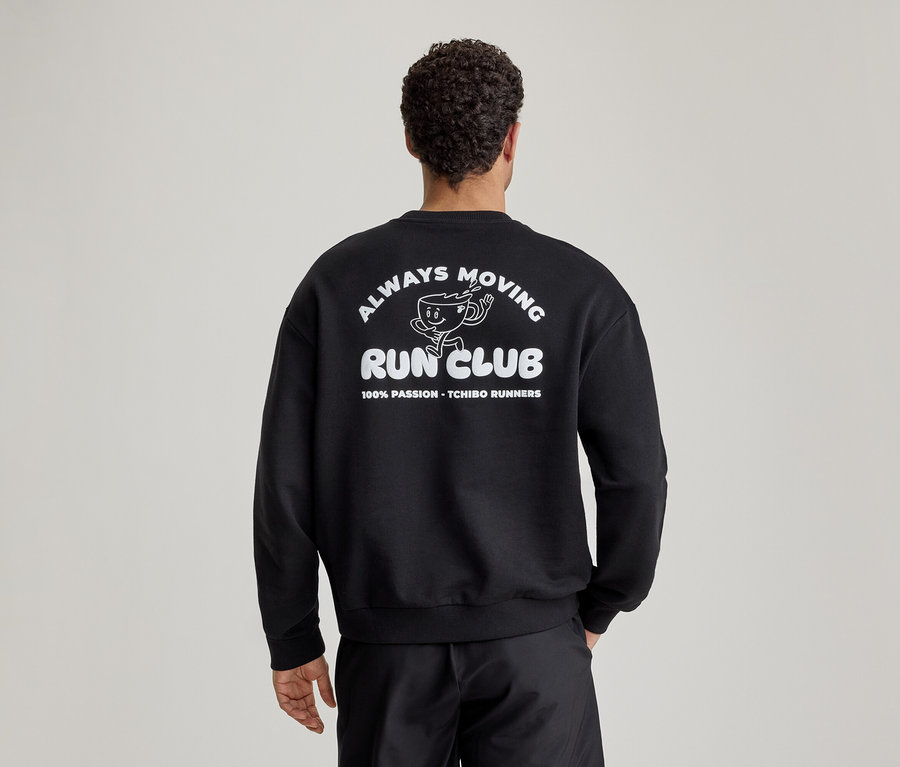 Homme de dos portant un sweatshirt noir avec l'inscription blanche 'ALWAYS MOVING RUN CLUB' et un dessin de tasse de café qui court au dos.