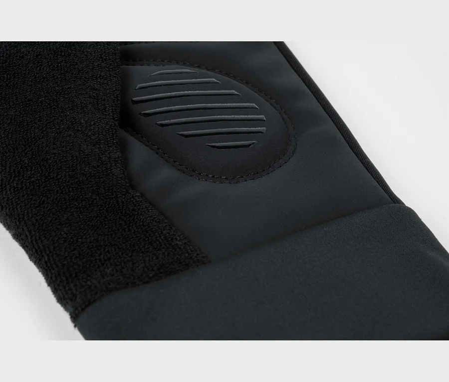Gant noir avec une section en tissu éponge, un tissu lisse et un patch ovale en caoutchouc en relief avec des nervures horizontales.