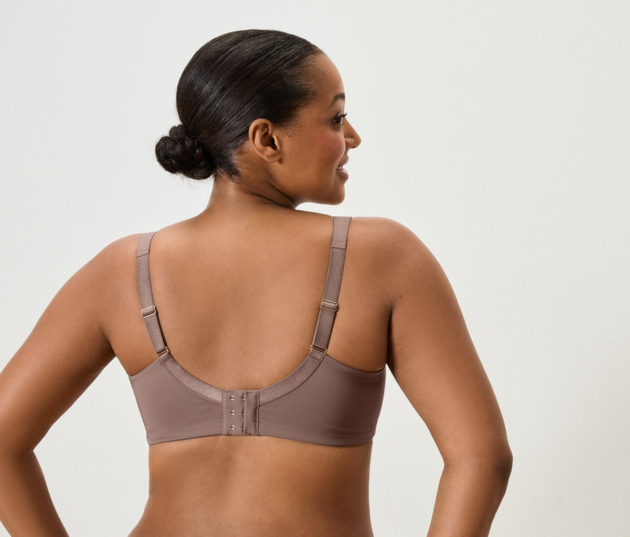 Vue arrière d'une femme aux cheveux relevés portant un soutien-gorge taupe.