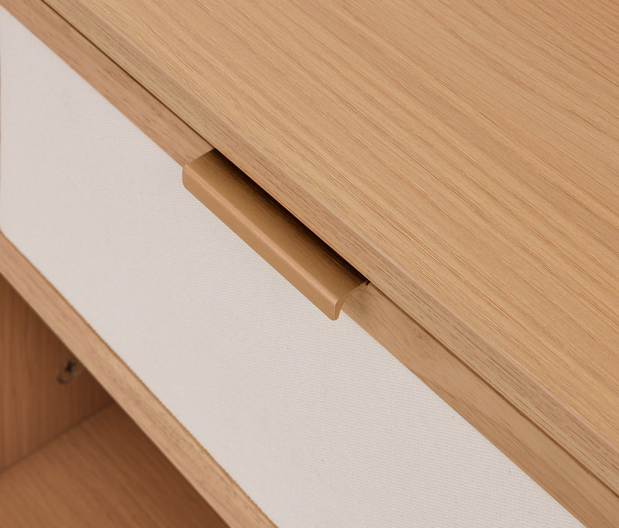 Tiroir en bois clair avec façade en tissu crème et poignée en bois intégrée.