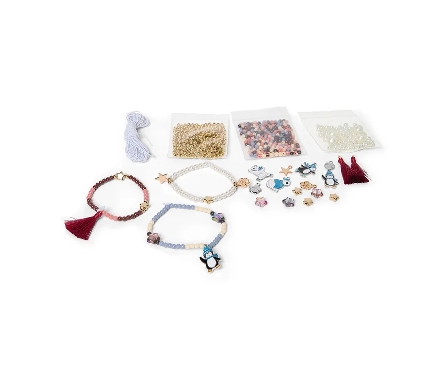Kit de fabrication de bracelets avec trois bracelets finis, des sachets de perles dorées, multicolores et nacrées, diverses breloques et du fil bleu clair sur fond blanc.