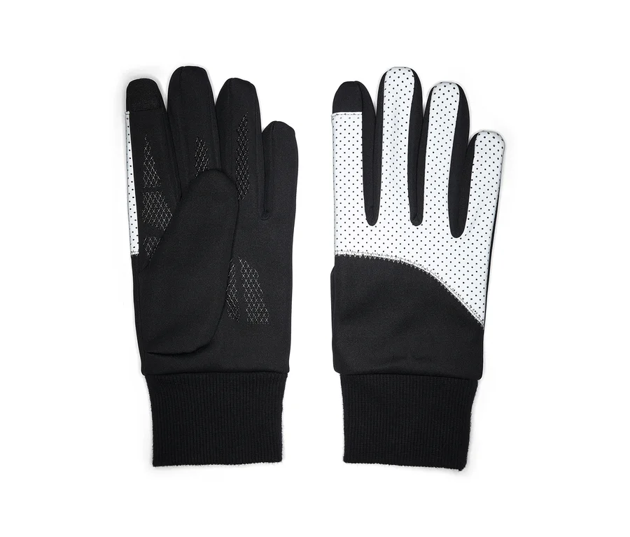 Une paire de gants noirs et blancs posés à plat. Le gant gauche montre la paume noire avec un motif texturé et une bande blanche à pois sur le pouce et l'index. Le gant droit montre le dos blanc avec des pois noirs et une section noire au poignet. Les deux ont des poignets côtelés noirs et des bouts de doigts compatibles avec les écrans tactiles.