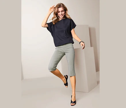 Femme posant en pantalon stretch 3/4 à rayures et haut noir.