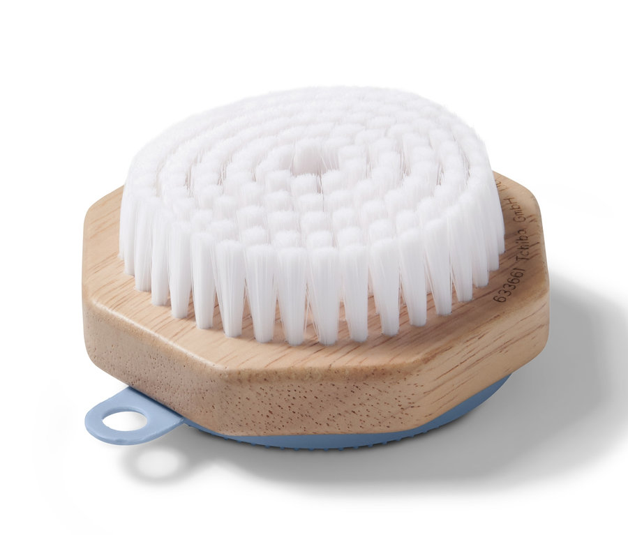 Brosse de nettoyage pour le visage avec des poils blancs et un manche en bois.