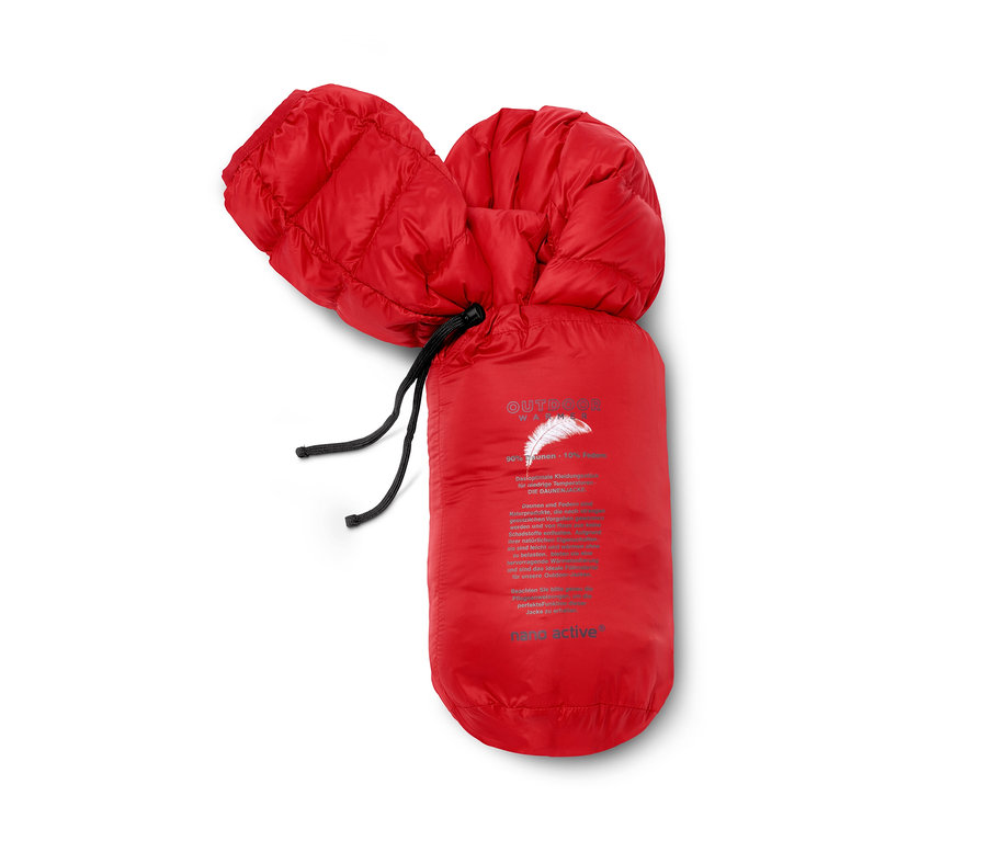 Une veste en duvet rouge emballée dans une housse.