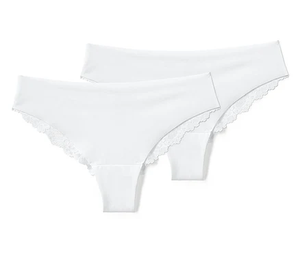 Deux tangas brésiliens blancs Magic Cut avec de la dentelle sont posés l'un sur l'autre.