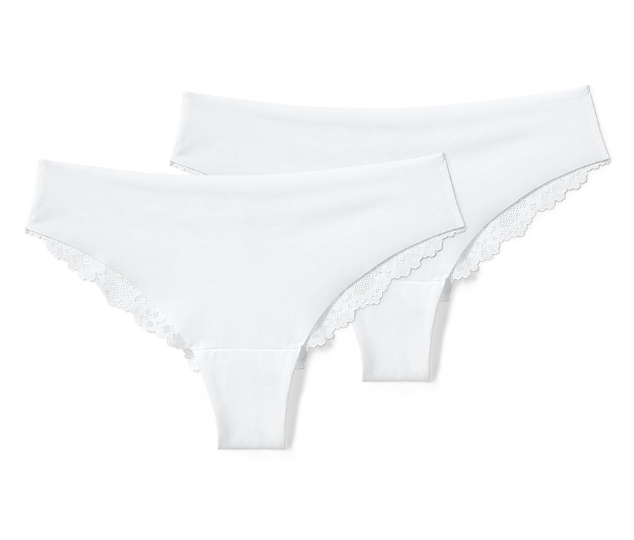 Deux tangas brésiliens blancs Magic Cut avec de la dentelle sont posés l'un sur l'autre.