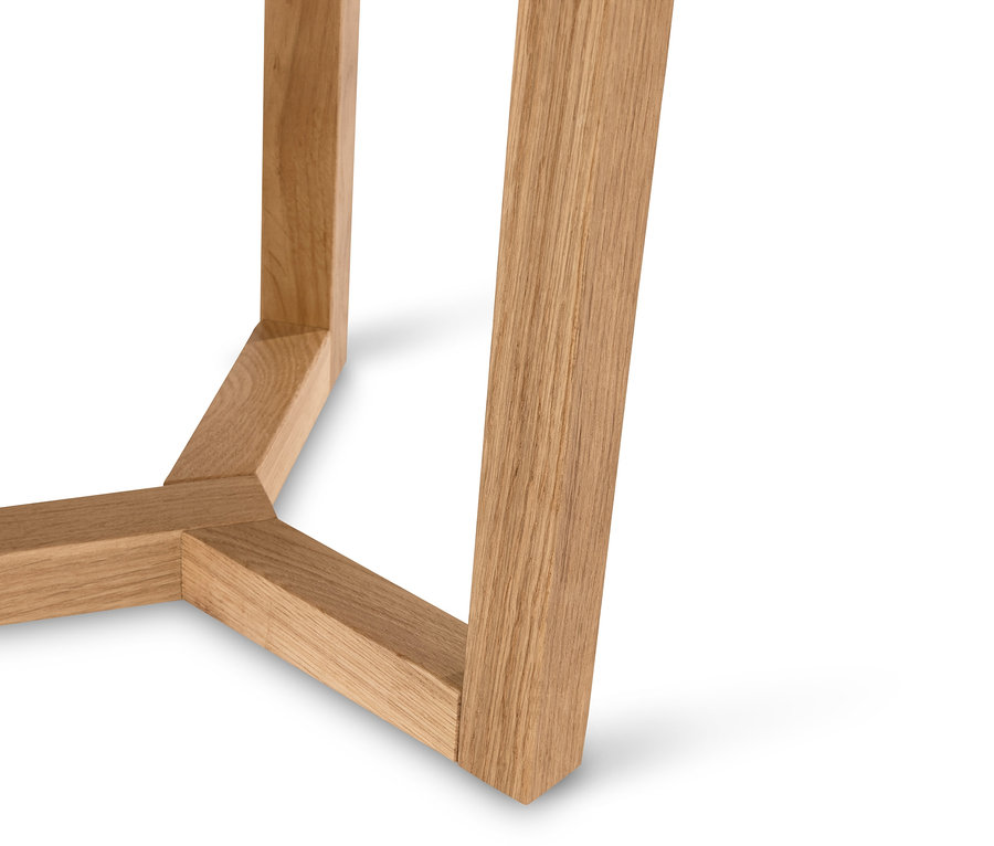 Gros plan sur le pied d'une table d'appoint en bois sur un fond blanc.