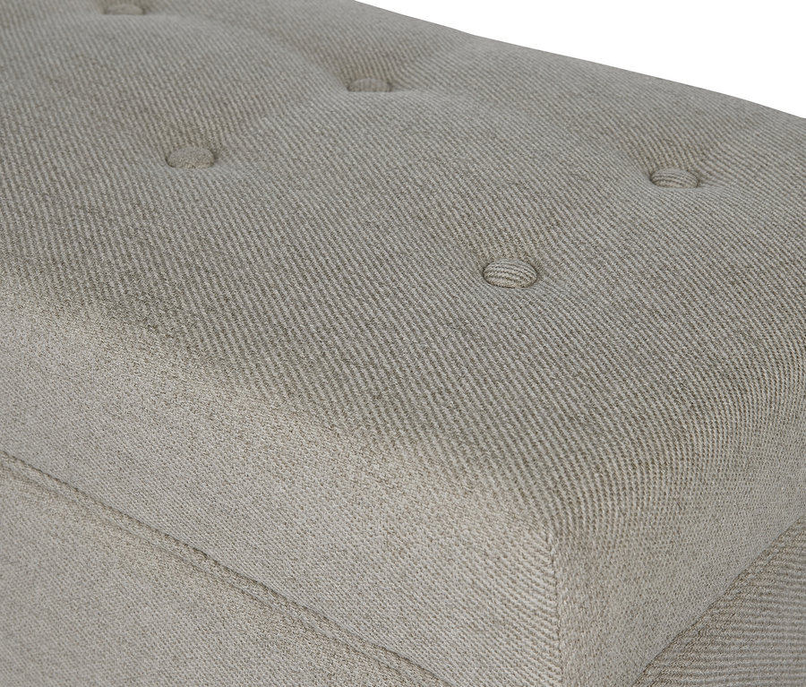 Gros plan d'un banc rembourré gris avec espace de rangement.