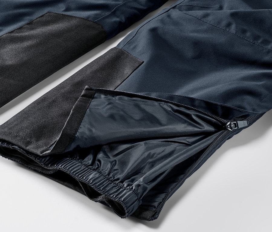 Gros plan sur un pantalon de ski high-tech bleu avec une fermeture éclair sur la jambe.