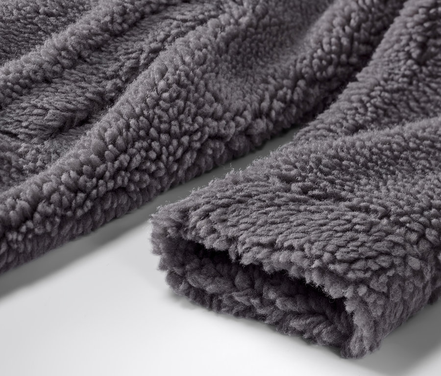 Détail d'un manteau en teddy avec capuche.