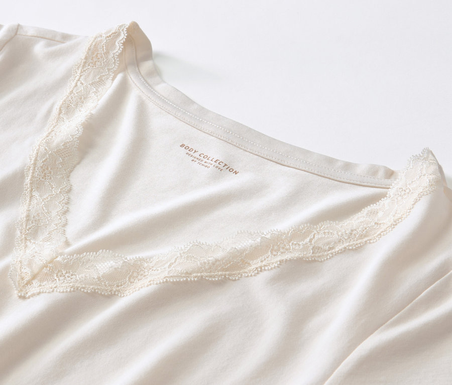Gros plan sur un pyjama crème à imprimé intégral avec encolure en V ornée de dentelle.