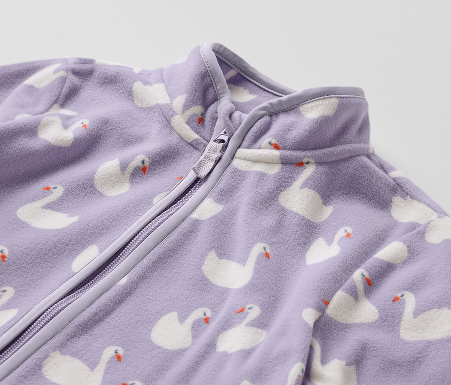 Gros plan sur une veste polaire pour enfant avec un motif de cygnes.
