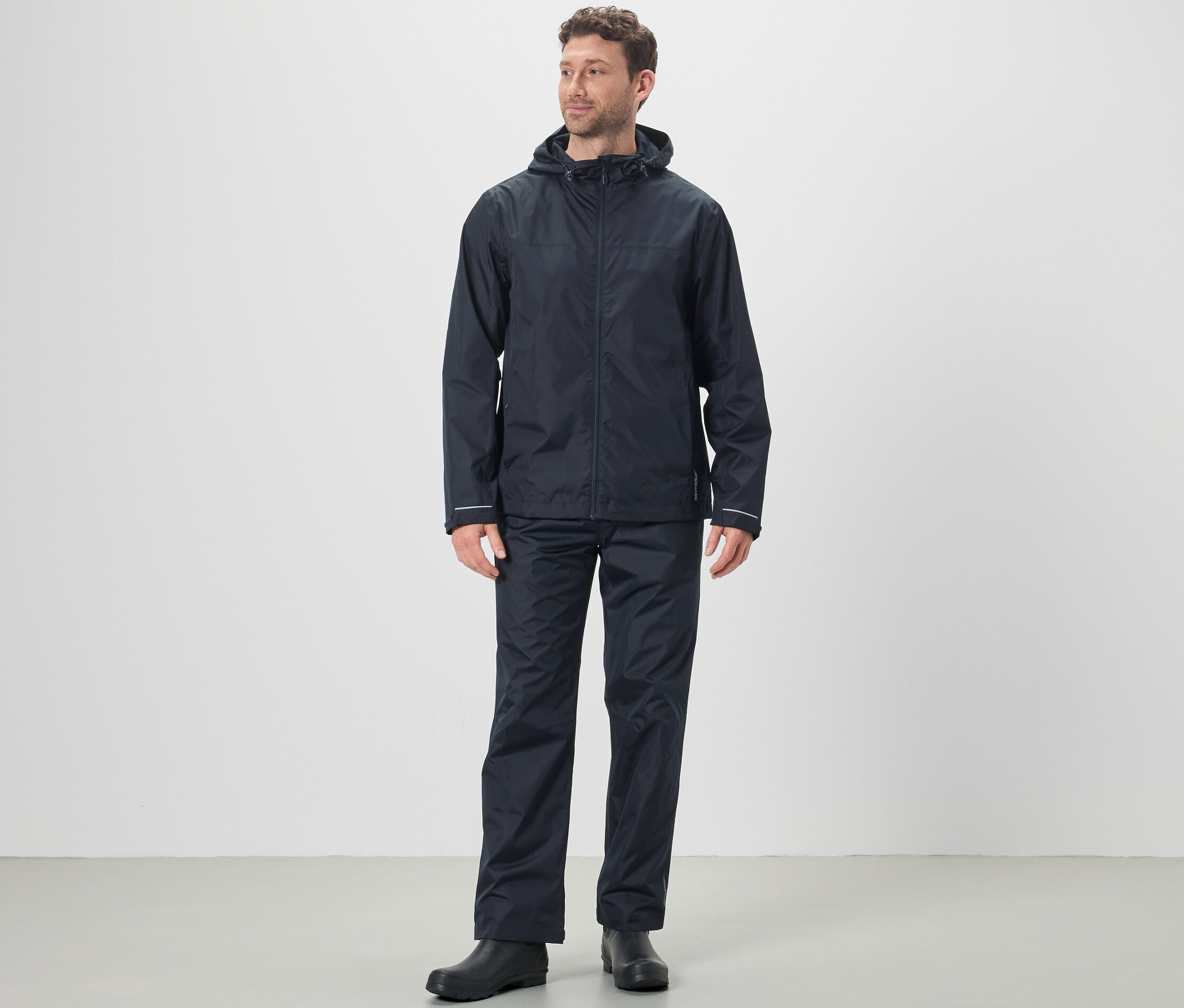 Un homme porte une veste de pluie et un pantalon de pluie unisexe.