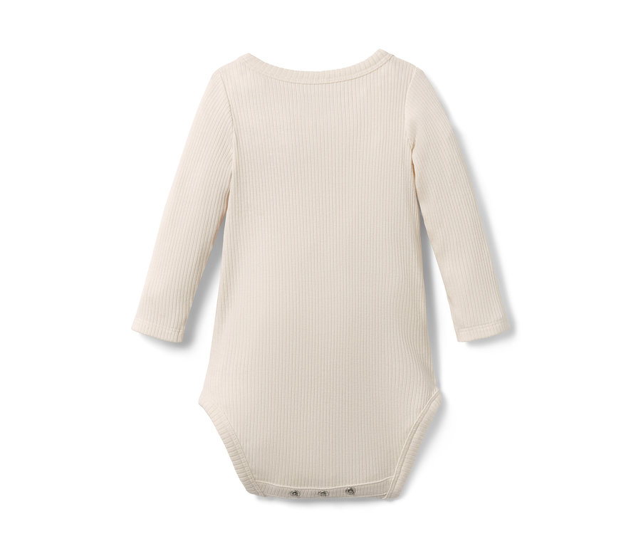 Gros plan sur un body pour bébé avec modal de couleur crème.