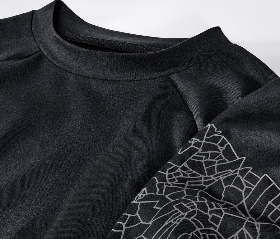 Gros plan sur un t-shirt technique à manches longues noir et argenté.