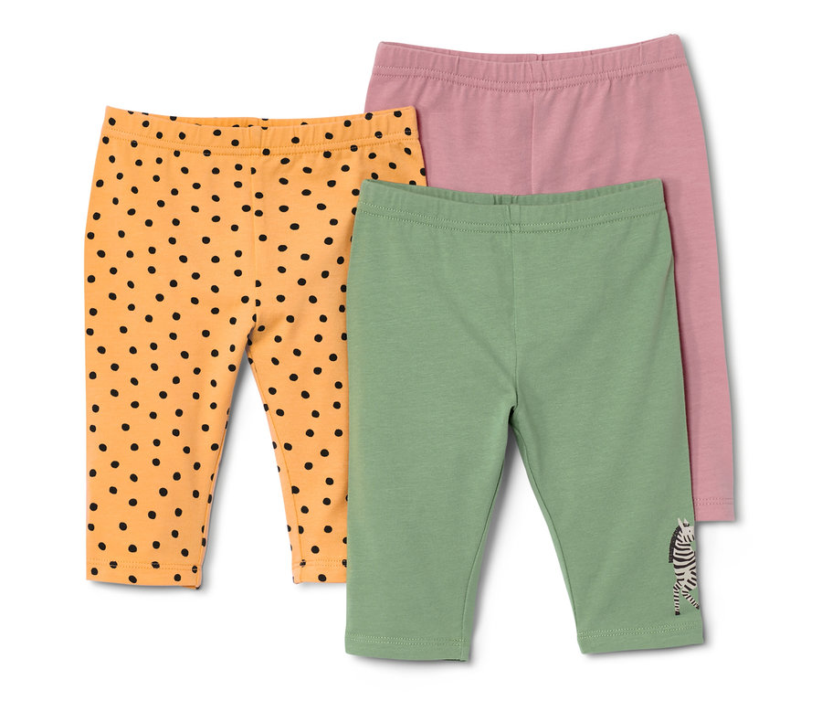Trois leggings pour enfant : orange avec des pois noirs, vert avec un zèbre et rose.