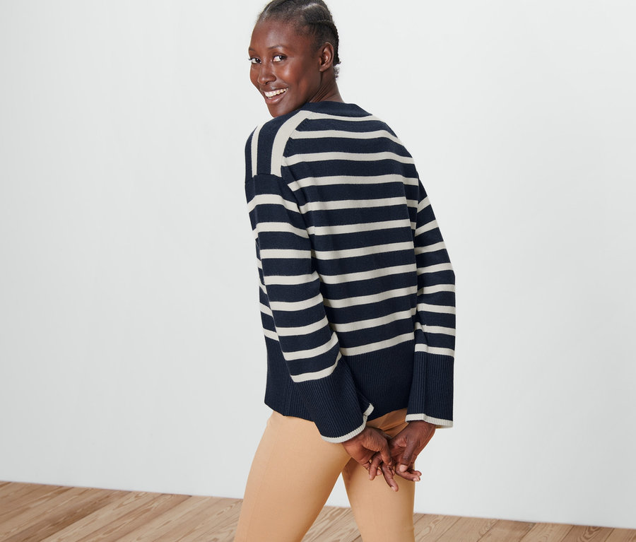 Femme regardant par-dessus son épaule portant un cardigan à rayures.