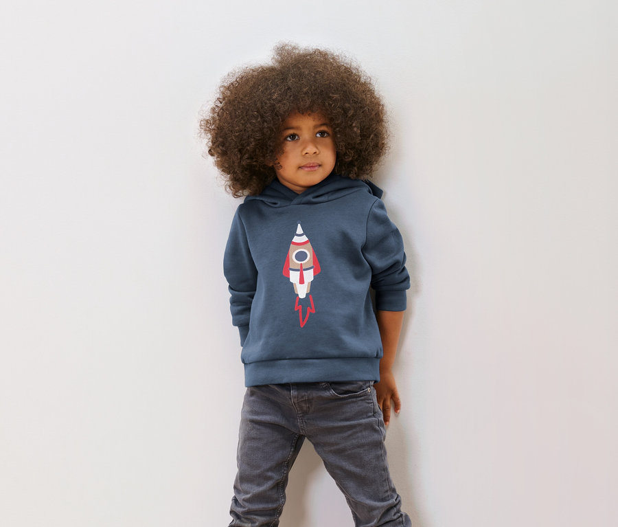 Garçon avec une coupe afro posant dans un sweatshirt pour enfant avec motif en paillettes réversibles, fusée ou imprimé (taille 86/92).