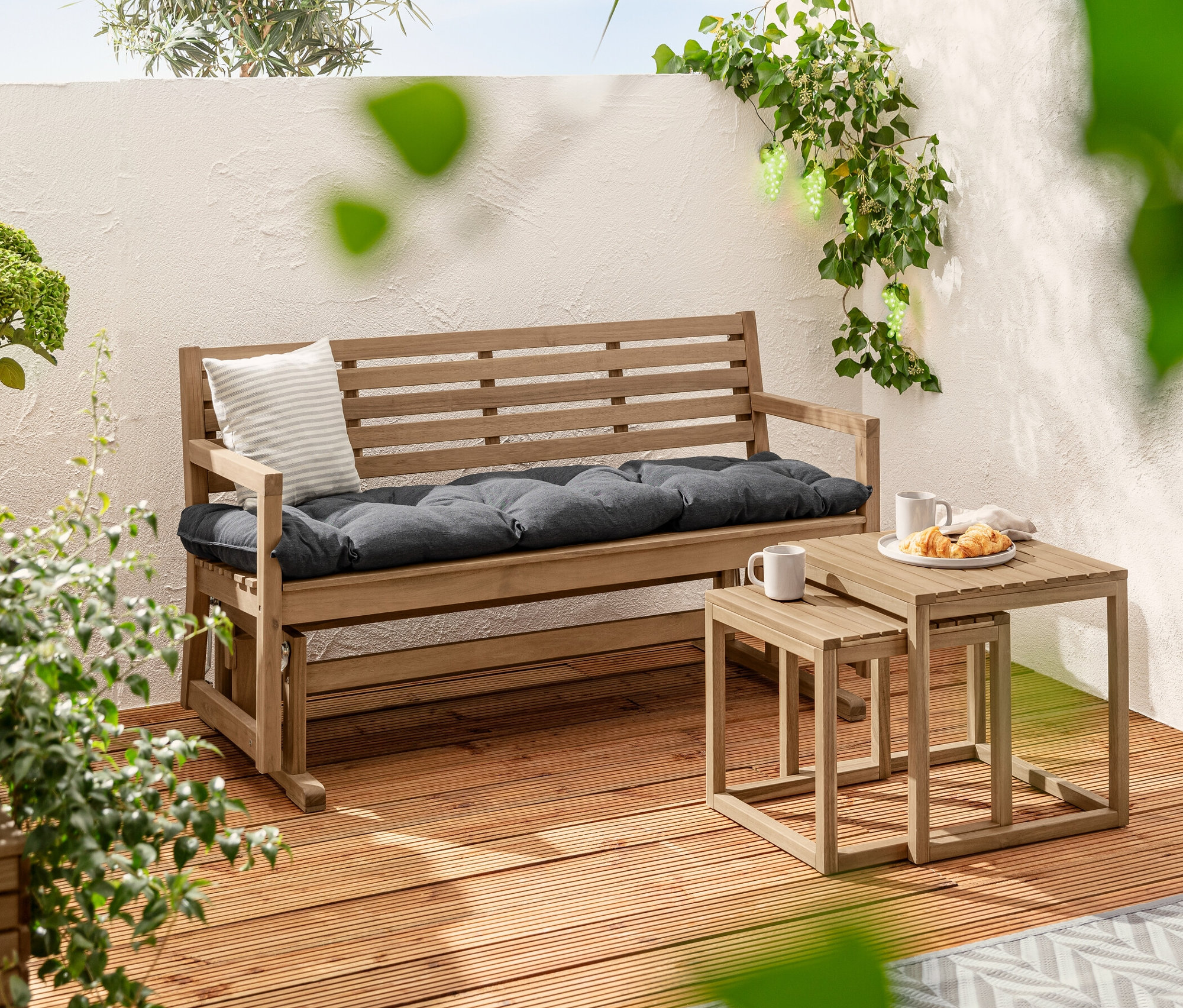 Deux tables d'appoint «	Lenja	» sont placées à côté d'un banc de jardin avec un coussin Sun Garden d'environ 160 x 50 cm. À l'arrière-plan, on trouve 2 lampes solaires enfichables Premium et une guirlande lumineuse solaire «	Grains de raisins	».