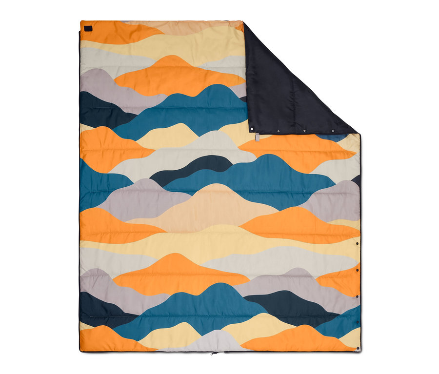 Sac de couchage 4 en 1 déplié avec motif de montagne coloré et doublure bleu foncé.