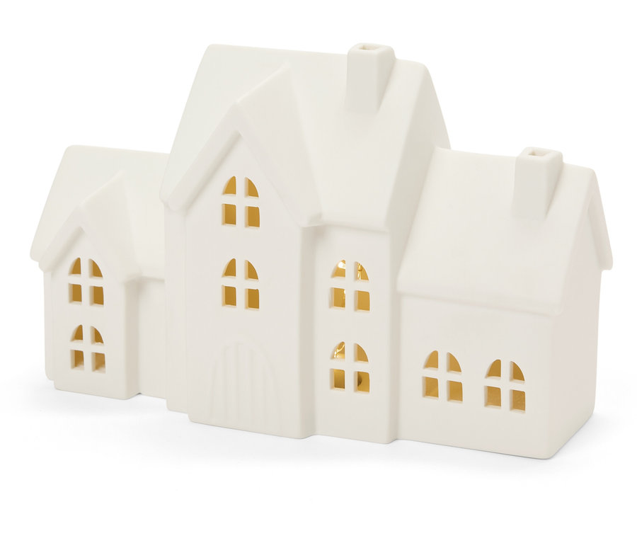 Maison décorative en porcelaine avec des lumières aux fenêtres.