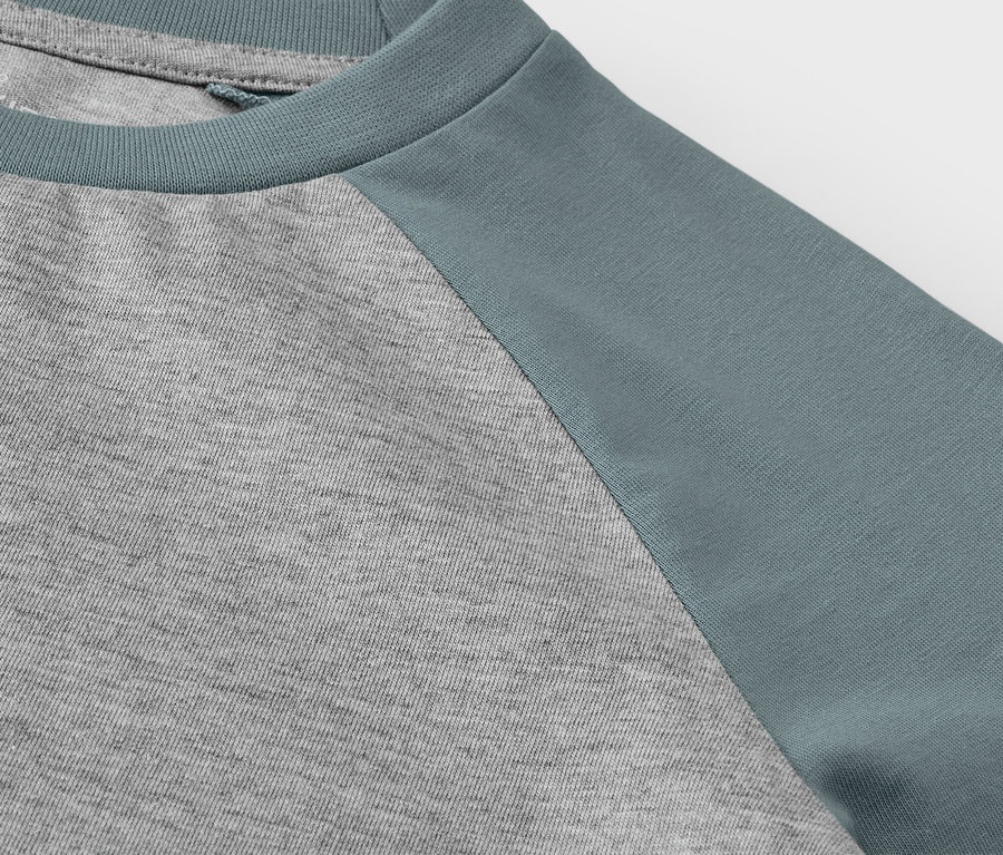 Gros plan sur un t-shirt à manches longues gris et bleu pour enfant.