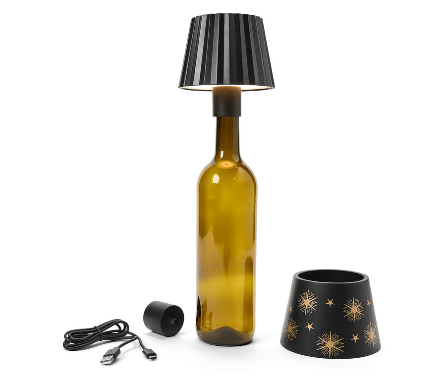 Lampe avec abat-jour noir sur bouteille, à côté câble USB, cylindre noir et abat-jour avec étoiles.