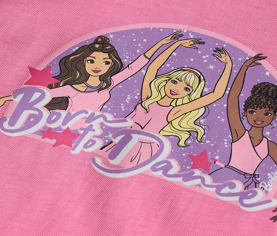 Sur un fond rose, illustration de trois personnages Barbie en position de ballet avec l'inscription "Born to Dance".