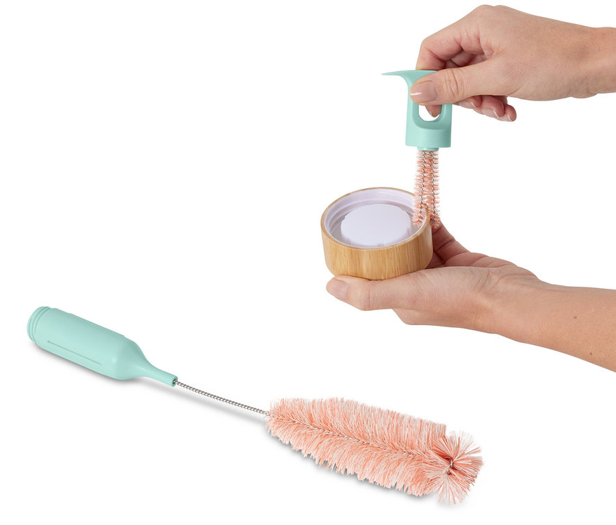 Une femme utilise une brosse à vaisselle pour verres et bouteilles 3 en 1.