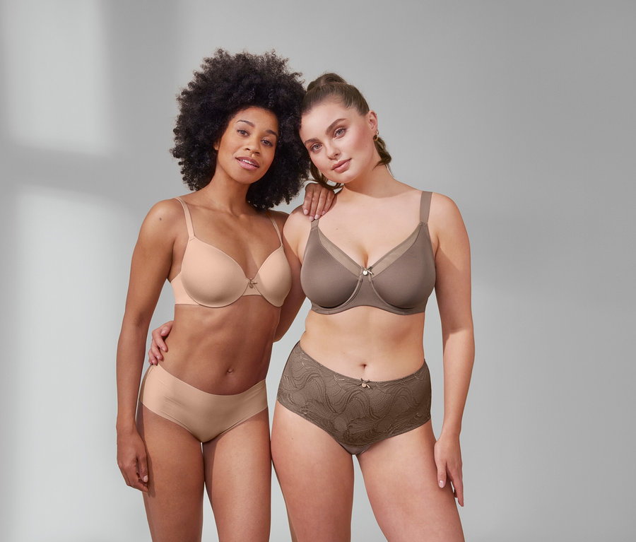 Deux femmes posent en soutien-gorge invisible et 5 culottes Magic Cut beiges, et en soutien-gorge minimiseur et panty taille haute « sculptant légèrement la silhouette » nougat.
