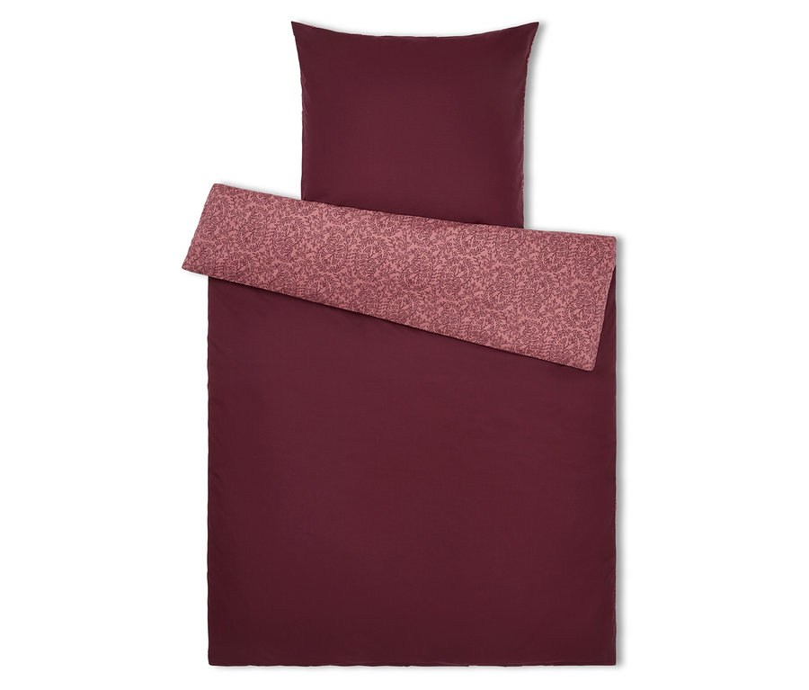 Linge de lit bordeaux avec motif floral sur le revers et l'oreiller.