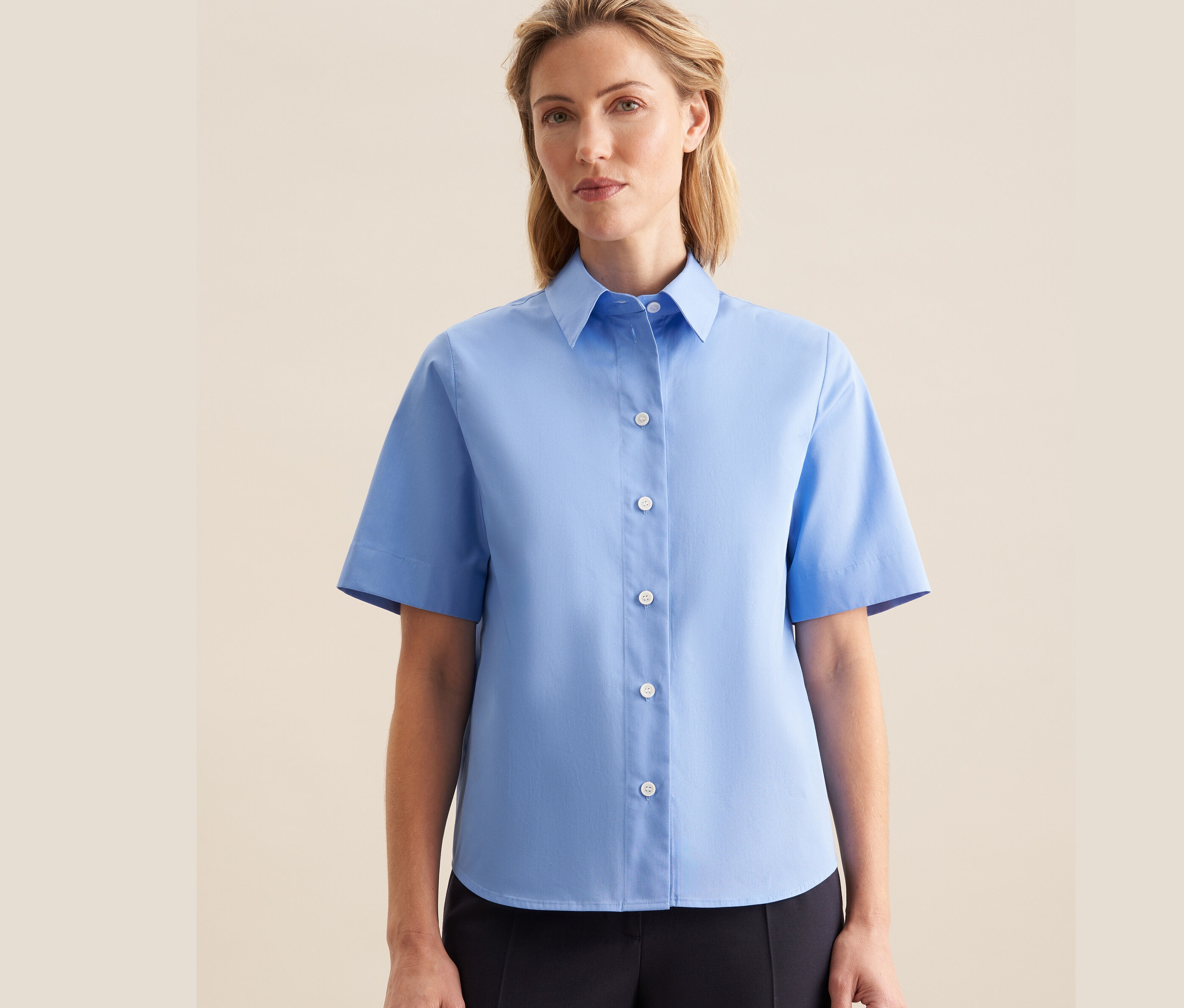Femme portant un chemisier à manches courtes Seidensticker bleu clair.