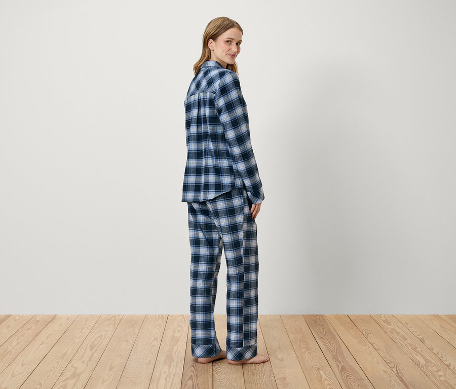 Femme posant en pyjama à carreaux bleus.