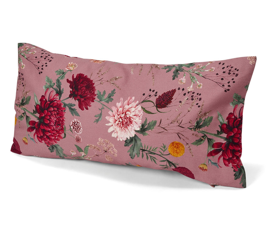 Coussin décoratif avec motif floral sur fond rose.